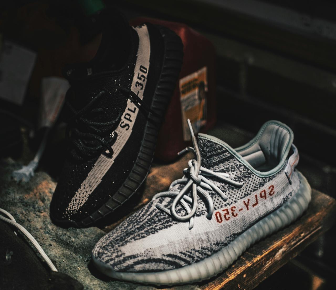 Close-up of Adidas Yeezy sneakers displaying unique design and style on a rustic table.
