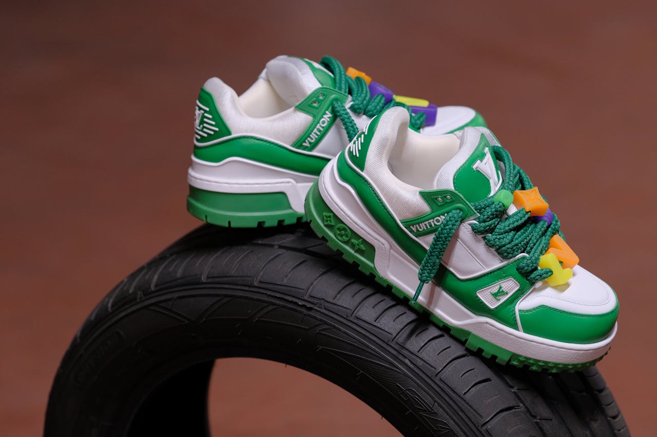 Stylish green and white sneakers artfully displayed on a tire, enhancing footwear appeal.