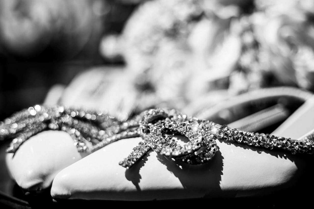 Close-up of elegant bridal shoes adorned with sparkling accessories, perfect for a timeless wedding.